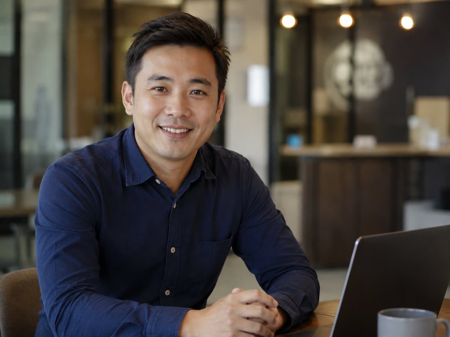 An accountant smiling at his laptop in an office